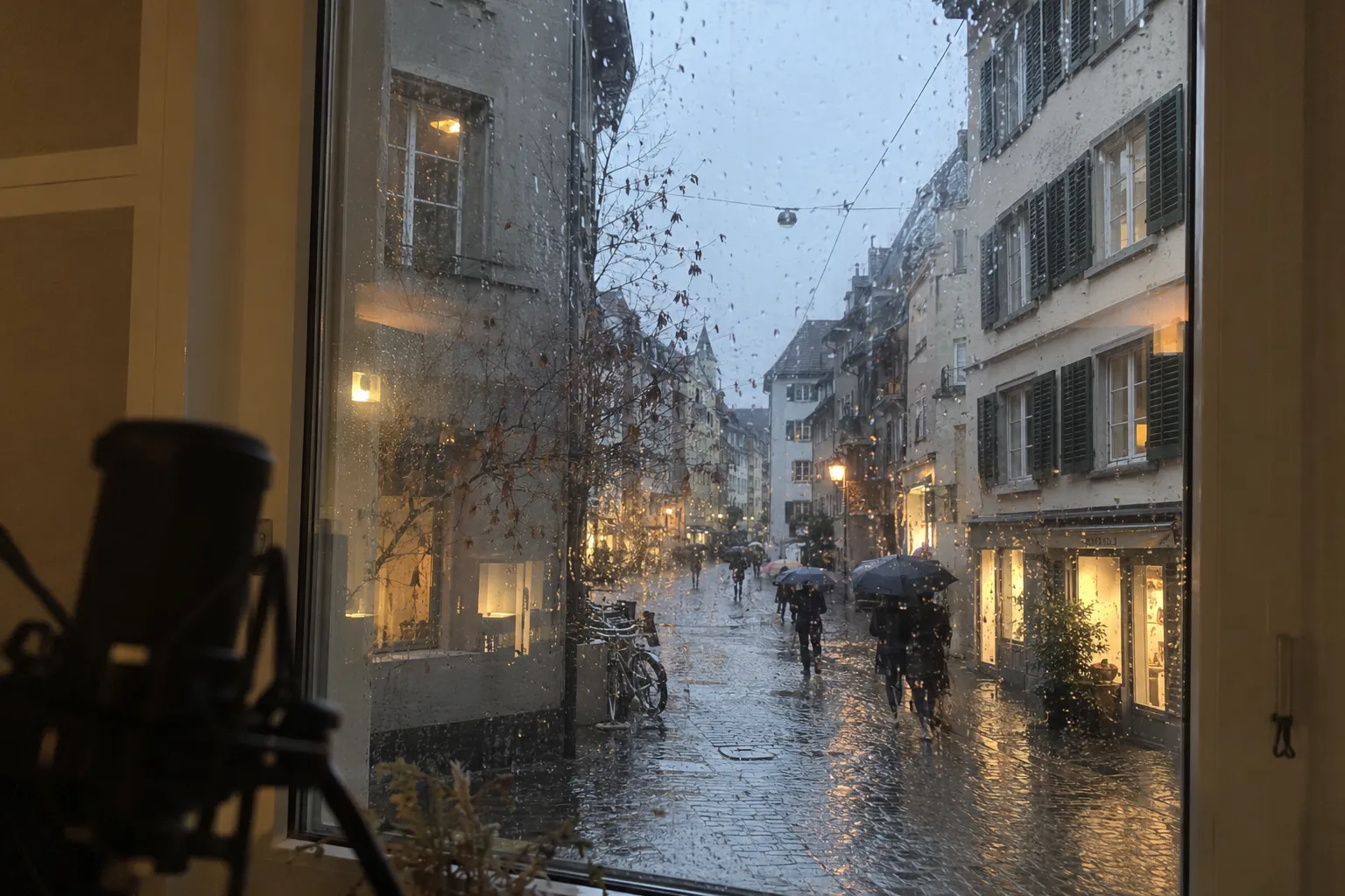 Regnerische Altstadtgasse in Zürich, durch ein Studiofenster gesehen